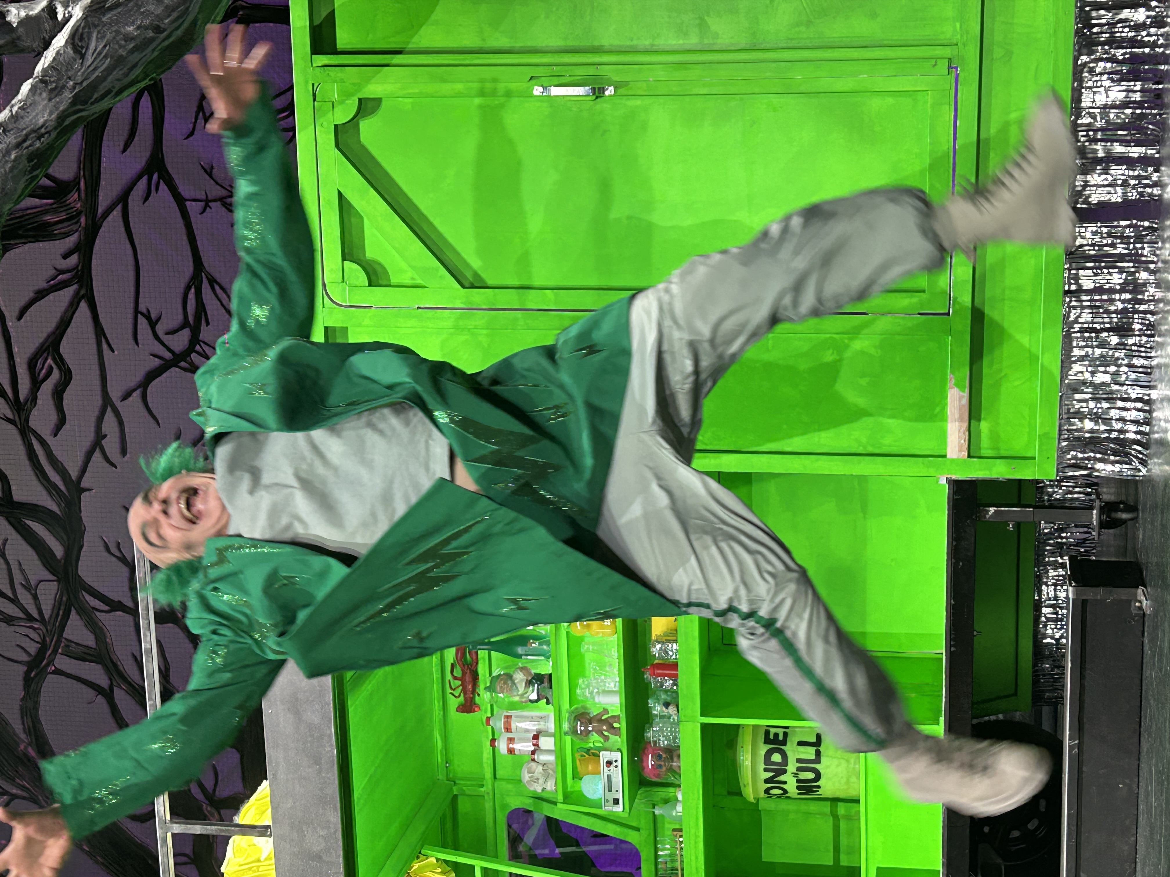 Figur mit Koffer vor grüner Bühne